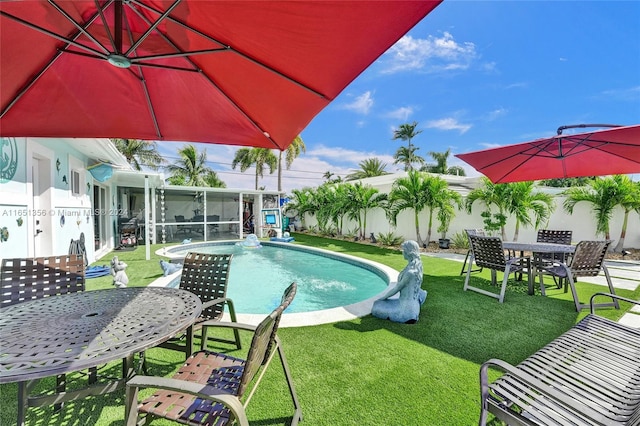 view of swimming pool with a patio area, a yard, and a sunroom