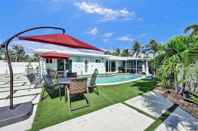 back of property with a fenced in pool, a yard, and a patio