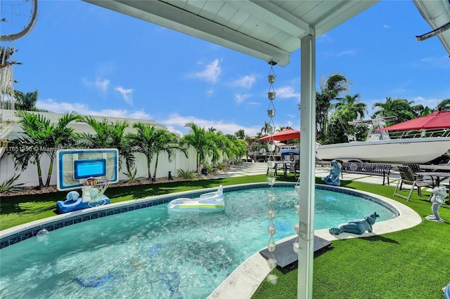 view of pool with a yard and pool water feature