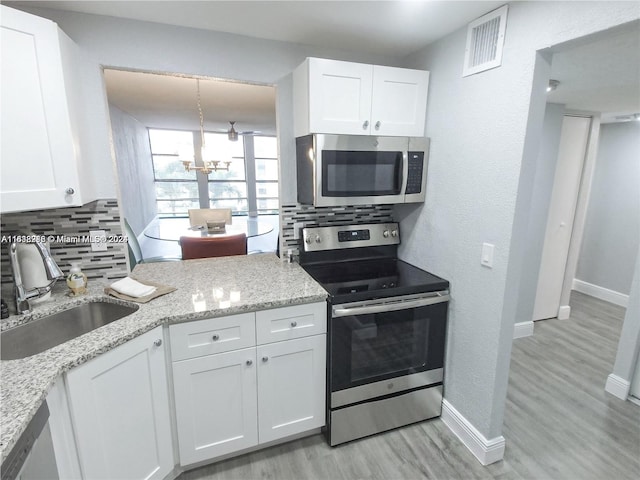 kitchen with stainless steel appliances, sink, and white cabinetry