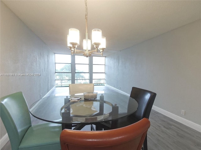 dining area with dark hardwood / wood-style floors and an inviting chandelier