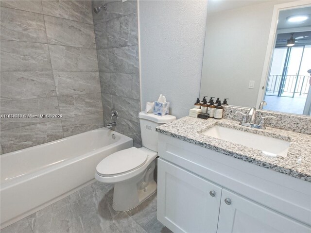 full bathroom with tiled shower / bath, vanity, and toilet