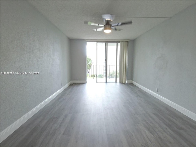 spare room with a textured ceiling, ceiling fan, and dark hardwood / wood-style flooring