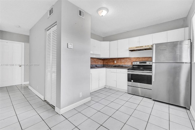 kitchen featuring a textured ceiling, light tile patterned floors, appliances with stainless steel finishes, and white cabinets