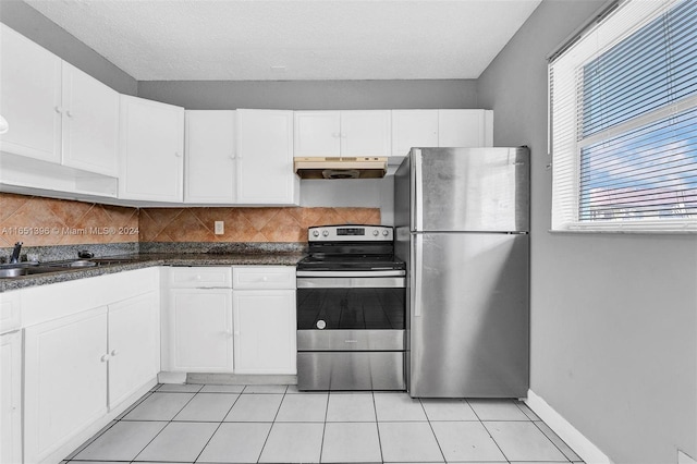 kitchen with white cabinetry, light tile patterned floors, sink, decorative backsplash, and appliances with stainless steel finishes