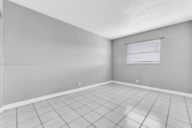 tiled spare room with a textured ceiling