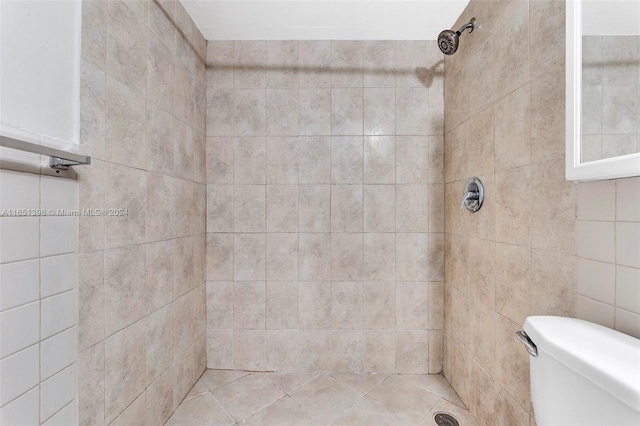 bathroom featuring toilet and a tile shower