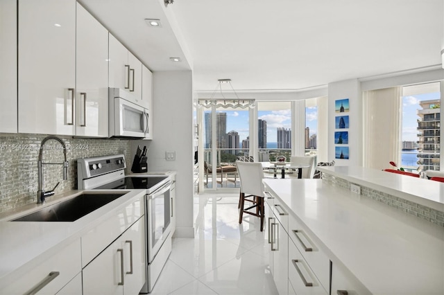 kitchen featuring white cabinetry, white appliances, decorative light fixtures, sink, and decorative backsplash