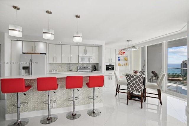 kitchen with pendant lighting, a breakfast bar area, appliances with stainless steel finishes, and tasteful backsplash