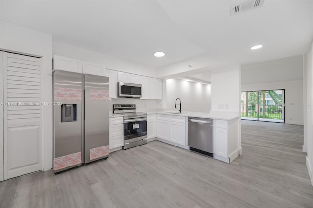 kitchen featuring sink, light hardwood / wood-style floors, white cabinetry, and stainless steel appliances