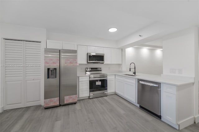 kitchen featuring sink, white cabinets, light hardwood / wood-style floors, and appliances with stainless steel finishes