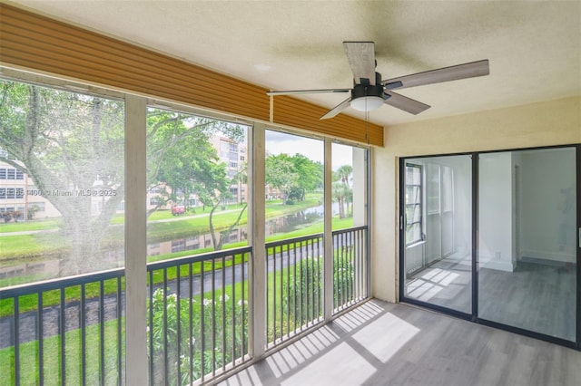 unfurnished sunroom featuring ceiling fan