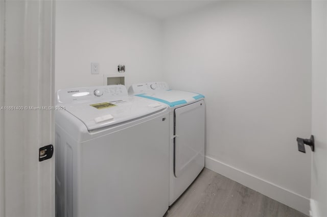 laundry area featuring light hardwood / wood-style floors and washing machine and clothes dryer