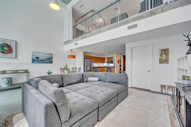 tiled living room featuring a towering ceiling