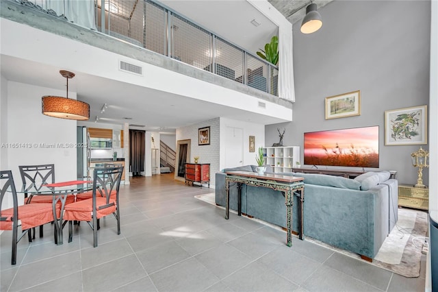 living room with light tile patterned floors and a towering ceiling