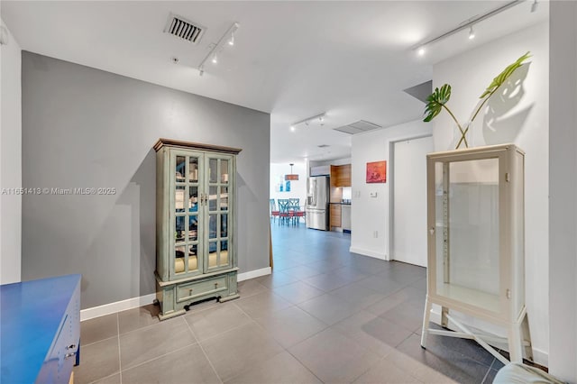 hall with light tile patterned flooring and rail lighting