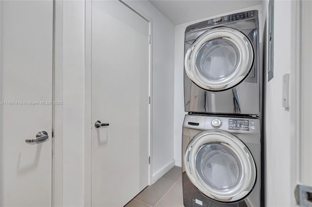 washroom with light tile patterned floors and stacked washer / dryer