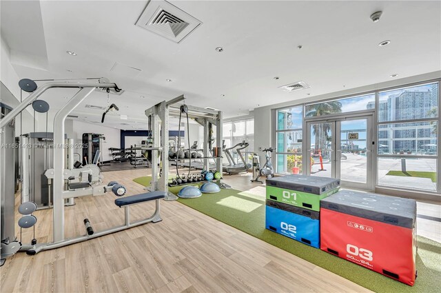 gym with hardwood / wood-style flooring and french doors