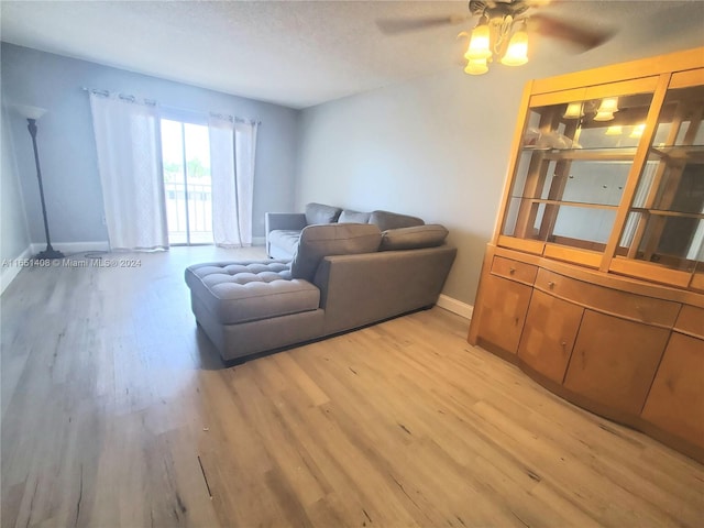 living room with hardwood / wood-style floors, ceiling fan, and a textured ceiling