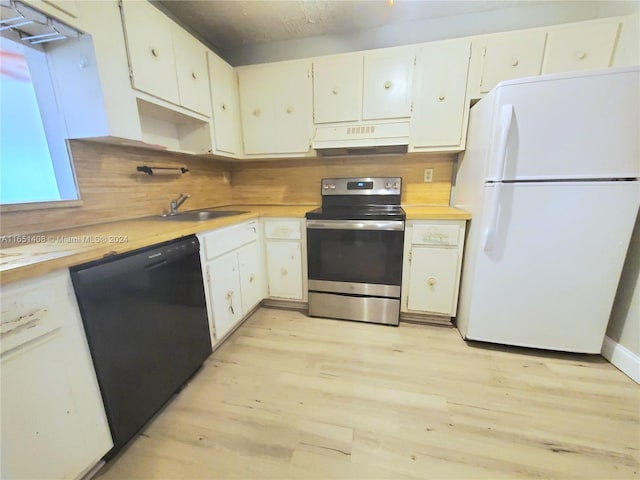 kitchen with dishwasher, light wood-type flooring, sink, white fridge, and stainless steel range with electric cooktop