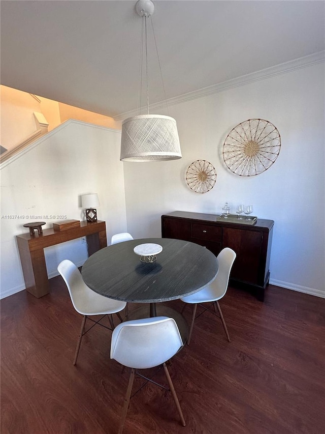 dining space featuring dark hardwood / wood-style flooring and crown molding