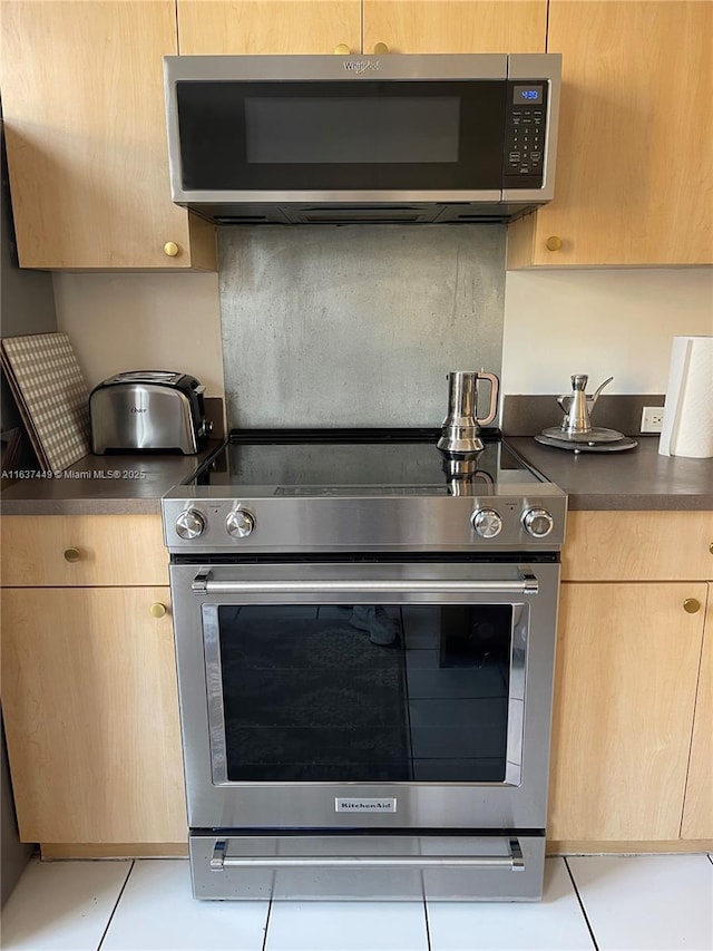 kitchen featuring appliances with stainless steel finishes, light brown cabinetry, and light tile patterned floors