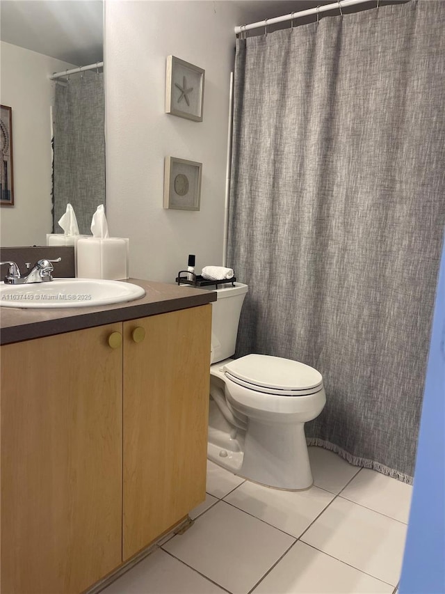 bathroom featuring vanity, curtained shower, tile patterned floors, and toilet