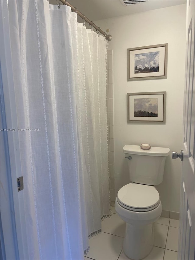 bathroom with walk in shower, tile patterned floors, and toilet