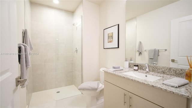 bathroom featuring tiled shower, vanity, and toilet