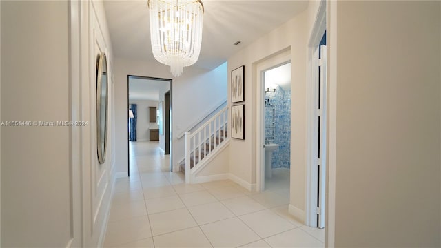 corridor featuring an inviting chandelier and light tile patterned floors