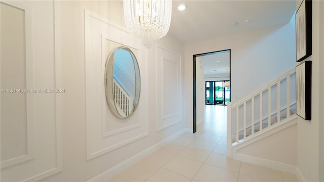 entryway with light tile patterned floors and a chandelier