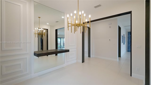 interior space featuring a chandelier, light tile patterned floors, and a barn door