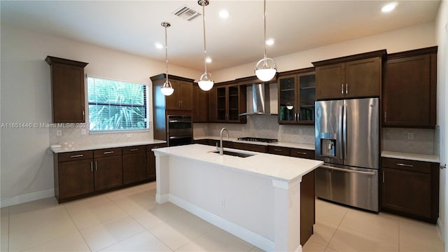 kitchen featuring backsplash, sink, wall chimney range hood, and appliances with stainless steel finishes