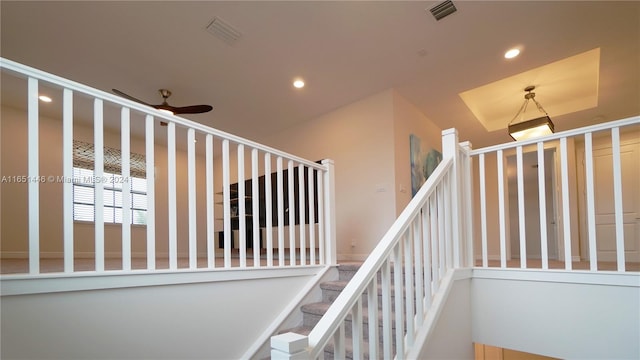 stairway featuring ceiling fan