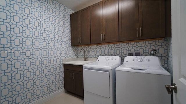 washroom featuring cabinets, washing machine and dryer, and sink