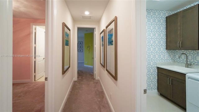 hall with sink and light carpet