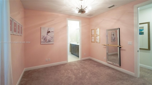 carpeted spare room with a chandelier