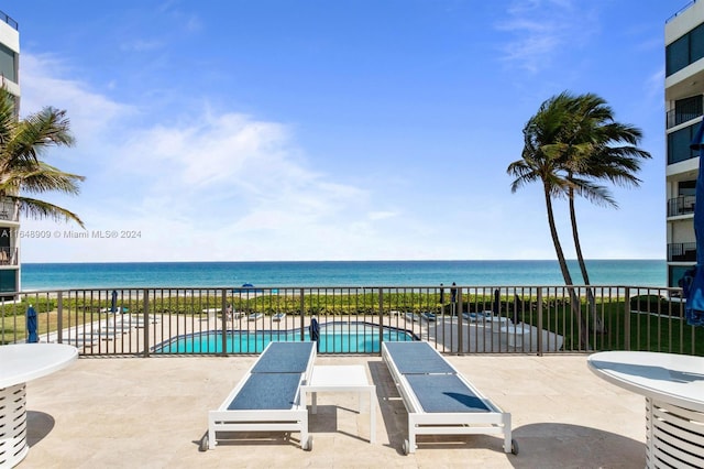 view of patio with a community pool and a water view