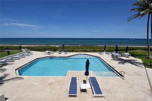 pool with a patio area and a water view