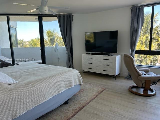 bedroom with access to outside and light wood-type flooring