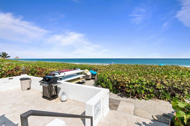 view of patio featuring a beach view and a water view