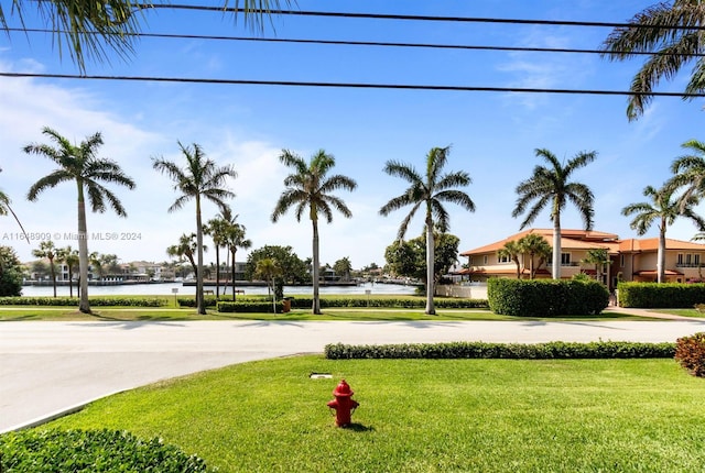 view of property's community with a lawn and a water view