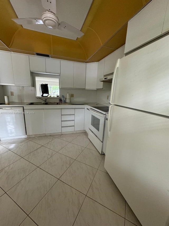 kitchen with white appliances, sink, light tile patterned floors, and white cabinets