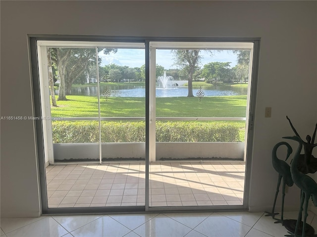 doorway to outside featuring a water view and light tile patterned floors