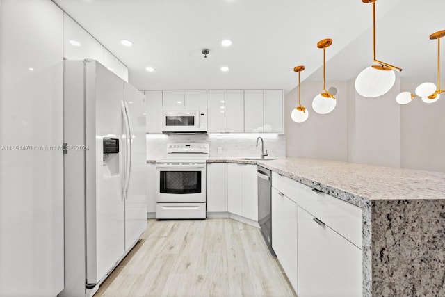 kitchen with hanging light fixtures, kitchen peninsula, white appliances, white cabinetry, and light hardwood / wood-style floors