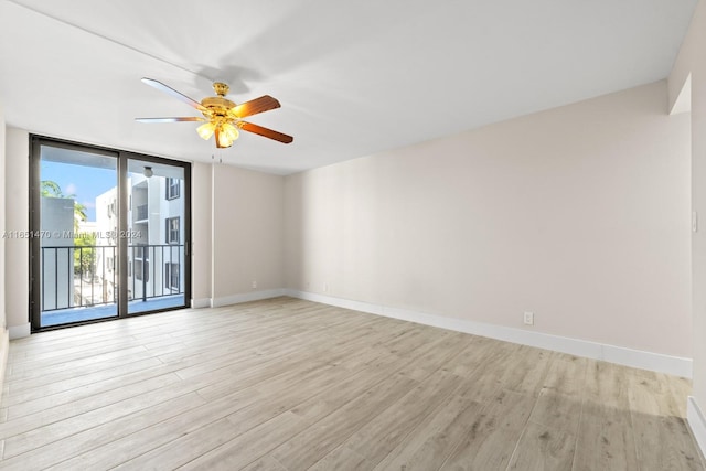 empty room with ceiling fan and light hardwood / wood-style flooring