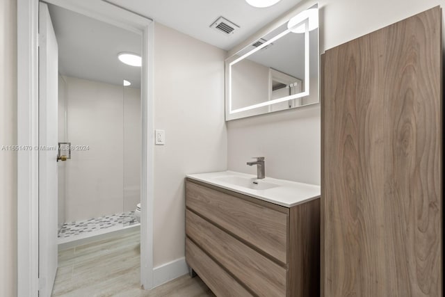 bathroom with vanity, a shower, toilet, and wood-type flooring