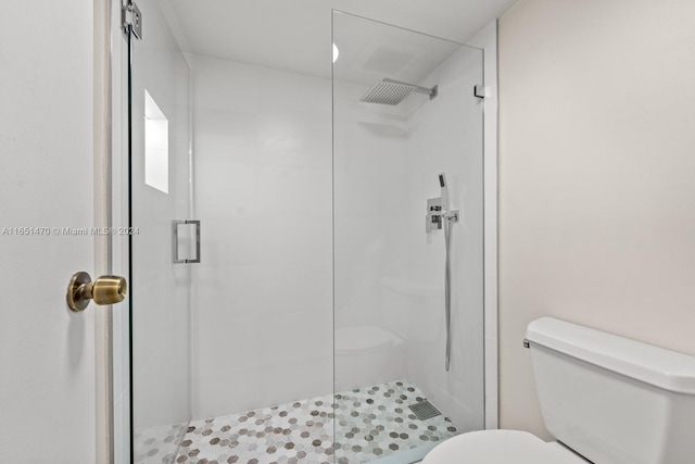 bathroom featuring toilet and a shower with shower door