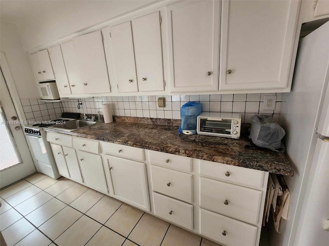 kitchen featuring light tile patterned flooring, backsplash, white cabinets, and white fridge