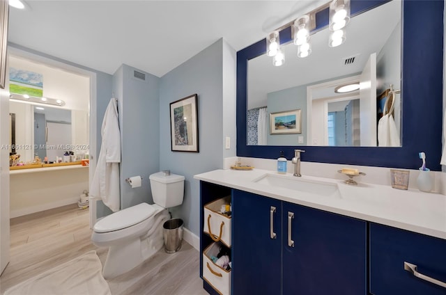 bathroom with vanity, toilet, and wood-type flooring